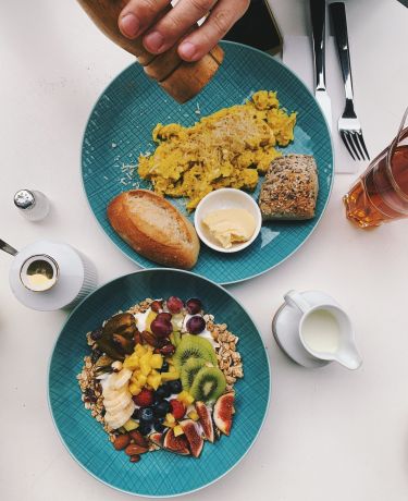 Ein Frühstückstisch im Café mit Müsli und Rührei