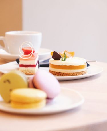 Macarons und Patisserie auf weißem Geschirr