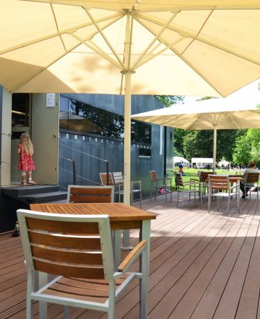 Café-Terrasse mit Holzboden und Sonnenschirmen