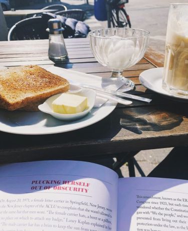 Toast, Butter und ein Kaffee auf dem sonnigen Tisch draußen vor dem Le Café